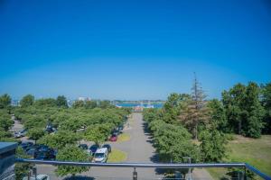 une vue aérienne sur un parking avec des voitures dans l'établissement Inselblume 78 - Ferienwohnung mit Strandkorb in Burgtiefe, à Burgtiefe auf Fehmarn 