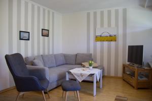 un salon avec un canapé et une table dans l'établissement Inselblume 15 - Ferienwohnung mit Garten, in absoluter Ruhe, à Neue Tiefe Fehmarn