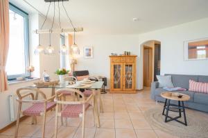 a living room with a table and chairs and a couch at Inselblume 56 - Ferienwohnung am Südstrand mit Meerblick in Burgtiefe auf Fehmarn 
