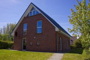 a red brick house with a gambrel roof at Inselblume 27 - Modernes Ferienhaus mit Garten in Burg in Burg auf Fehmarn