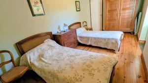 a bedroom with two beds and a dresser at Gîte en pierre maison quercynoise in Vaylats