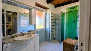 a bathroom with a sink and a green shower at Gîte en pierre maison quercynoise in Vaylats