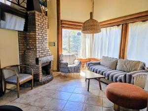 a living room with a couch and a fireplace at Cabañas Altos del Nopal in Ciudad Lujan de Cuyo