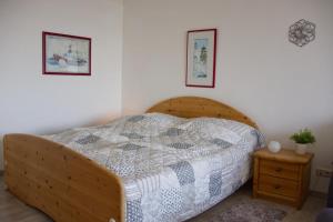 - une chambre avec un lit en bois et une couette dans l'établissement Inselblume 75 - Gemütliche Ferienwohnung mit Balkon und Meerblick, à Burgtiefe auf Fehmarn 