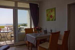 une salle à manger avec une table et un balcon dans l'établissement Inselblume 75 - Gemütliche Ferienwohnung mit Balkon und Meerblick, à Burgtiefe auf Fehmarn 