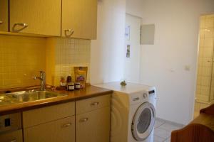 une cuisine avec une machine à laver et un évier dans l'établissement Inselblume 75 - Gemütliche Ferienwohnung mit Balkon und Meerblick, à Burgtiefe auf Fehmarn 