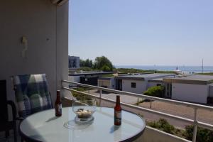 - une table avec 2 bouteilles et un bol sur le balcon dans l'établissement Inselblume 75 - Gemütliche Ferienwohnung mit Balkon und Meerblick, à Burgtiefe auf Fehmarn 