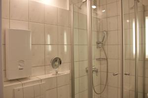 une salle de bain avec une douche avec une porte vitrée dans l'établissement Inselblume 75 - Gemütliche Ferienwohnung mit Balkon und Meerblick, à Burgtiefe auf Fehmarn  11 autres photos