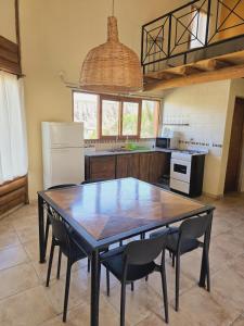 a kitchen with a table and chairs in a kitchen at Cabañas Altos de Nopal in Ciudad Lujan de Cuyo
