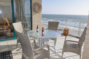 a table with two bottles of beer sitting on a patio at Inselblume 16 - Ferienwohnung mit Meerblick in der Strandburg B2.6 in Burgtiefe auf Fehmarn 