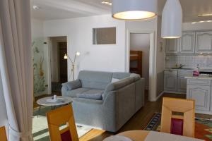 a living room with a couch and a kitchen at Inselblume 16 - Ferienwohnung mit Meerblick in der Strandburg B2.6 in Burgtiefe auf Fehmarn 