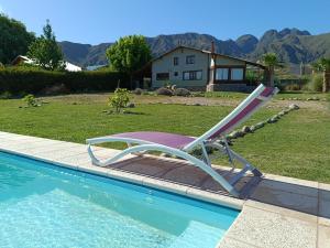 a lounge chair sitting next to a swimming pool at Cabañas Altos del Nopal in Ciudad Lujan de Cuyo