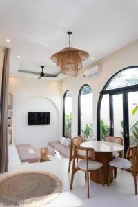 a living room with a table and chairs and windows at VILLA DAHO Mediterranean Elegance in Ungasan