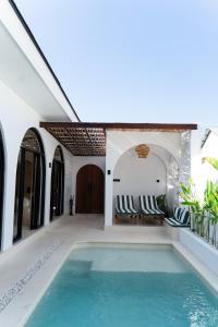 a swimming pool in a villa with two chairs at VILLA DAHO Mediterranean Elegance in Ungasan +10 photos