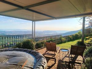 a patio with two chairs and a grill with a view at Apartman ANAMARIA in Klis