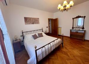 a bedroom with a bed with white sheets and a mirror at Novella Dimora, nel cuore verde di Costano in Costano