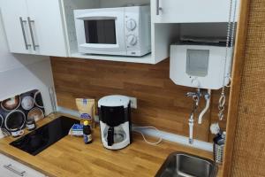 - un comptoir de cuisine avec une cafetière et un four micro-ondes dans l'établissement Inselblume 59 - Moderne Ferienwohnung mit Meerblick, à Burgtiefe auf Fehmarn 