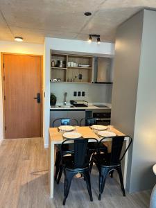 a dining room with a table and chairs and a kitchen at Link in Montevideo +4 photos