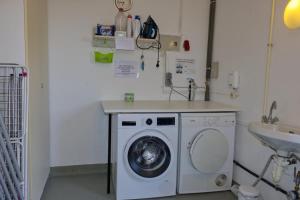 a laundry room with a washing machine and a sink at Inselblume 35 - Moderne Ferienwohnung in Neue Tiefe in Neue Tiefe Fehmarn