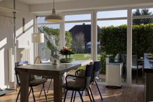 a dining room table with chairs and a large window at Inselblume 35 - Moderne Ferienwohnung in Neue Tiefe in Neue Tiefe Fehmarn
