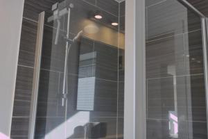 a shower in a bathroom with a glass door at Inselblume 35 - Moderne Ferienwohnung in Neue Tiefe in Neue Tiefe Fehmarn +17 photos