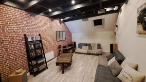 a living room with a couch and a brick wall at Halte détente chez Sylvie près A71 Bourges - chambres avec sauna, billard, salle ciné in Civray