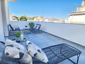 a balcony with a couch and chairs on a roof at Miracle Luxury Suites in Artemida