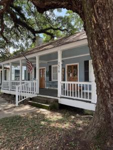 a white house with an american flag on the porch at Alice by Ravens Keep in Jackson