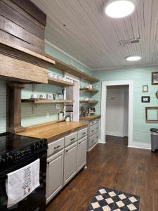 a large kitchen with a stove and wooden floors at Alice by Ravens Keep in Jackson