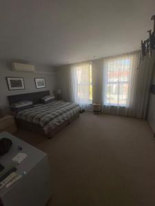 a bedroom with a bed and a large window at Secure Estate Home with 24 Hour Surveillance in Cape Town