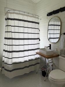 a bathroom with a black and white shower curtain and a sink at Alice by Ravens Keep in Jackson