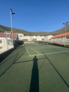a shadow of a person on a tennis court at Secure Estate Home with 24 Hour Surveillance in Cape Town