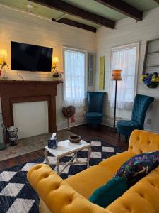a living room with a yellow couch and a fireplace at Alice by Ravens Keep in Jackson