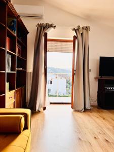 a living room with a large window with curtains at La Mansarda di Stella in Rieti +23 photos