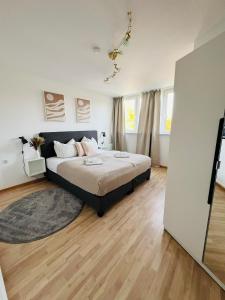 une chambre avec un grand lit et un parquet dans l'établissement AllgäuSchatz - Schöne 2-Zimmer Wohnung in zentraler Stadtlage, à Kempten