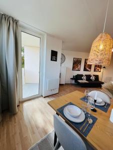 une salle à manger et un salon avec une table et des chaises dans l'établissement AllgäuSchatz - Schöne 2-Zimmer Wohnung in zentraler Stadtlage, à Kempten