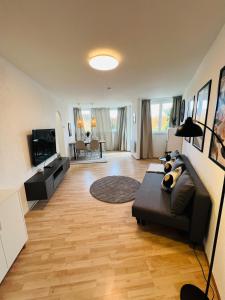 un salon avec un canapé et une télévision dans l'établissement AllgäuSchatz - Schöne 2-Zimmer Wohnung in zentraler Stadtlage, à Kempten 4 autres photos