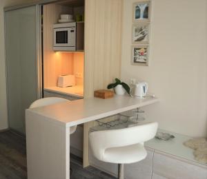 a kitchen with a white desk and a white chair at Aisa 39 Külaliskorter in Pärnu