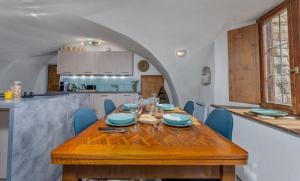 a dining room with a wooden table and blue chairs at Maison à Tour Briançon in Briançon