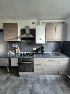 a kitchen with white cabinets and a stove top oven at Chez les Poilus in Verdun