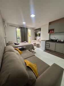 a living room with several couches and a kitchen at Flat luxo Tambaú in João Pessoa