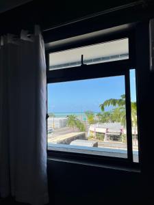 una ventana en una habitación con vistas al océano en Hotel Farol de Tambaú, en João Pessoa