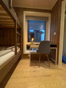 a bedroom with a desk and a bed and a window at Nice apartment on Geilotunet, Close to city center in Geilo