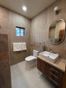 a bathroom with a toilet and a sink and a mirror at Posada de Amparo in Casas Grandes