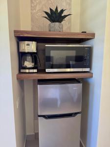 a microwave sitting on a shelf above a refrigerator at Posada de Amparo in Casas Grandes +8 photos
