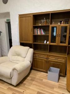 a living room with a chair and a book shelf at Artishalico tallinn in Tallinn