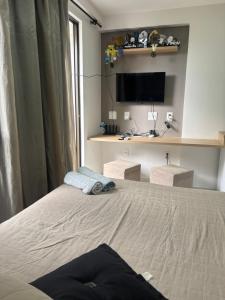 a bedroom with a bed and a tv on the wall at Flat luxo Tambaú in João Pessoa +8 photos