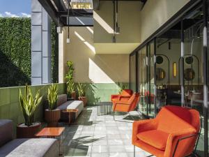 an outdoor patio with orange chairs and plants at Novotel Mexico City World Trade Center in Mexico City