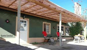 un patio con sillas rojas y pérgola de madera en Quinta Cavaluz, en Poceirão