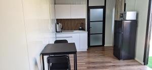 a small kitchen with a table and a refrigerator at הבקתות של מאי  +12 photos